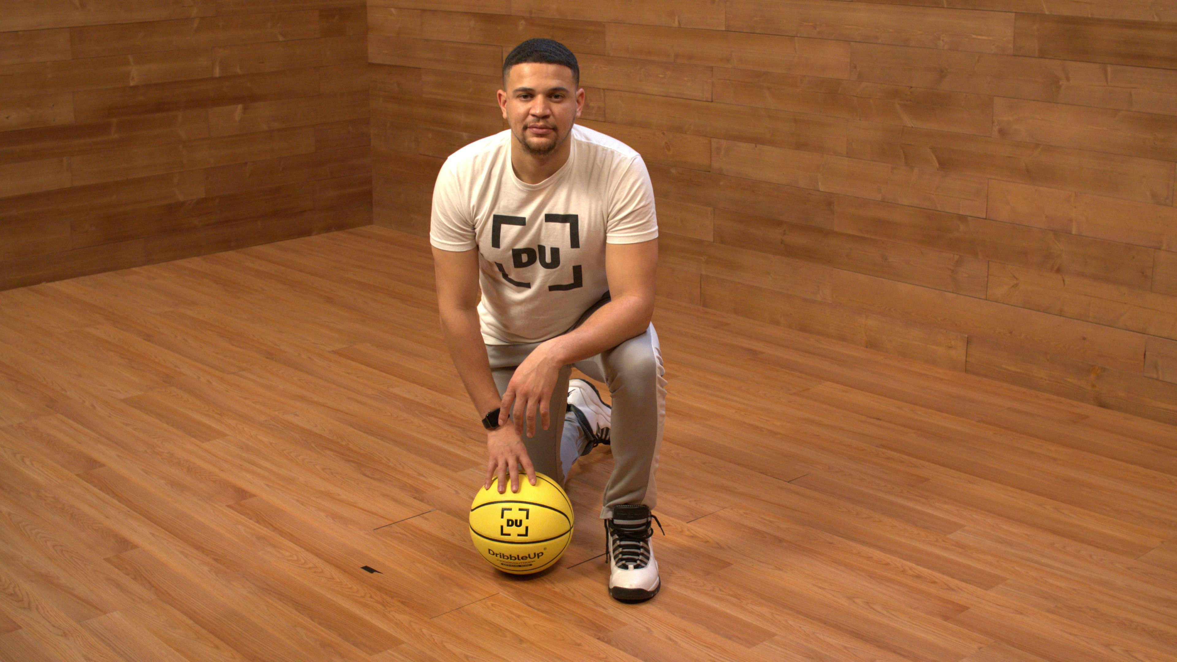 Basketball coach teaching young players how to do a V-Dribble with the Smart Basketball