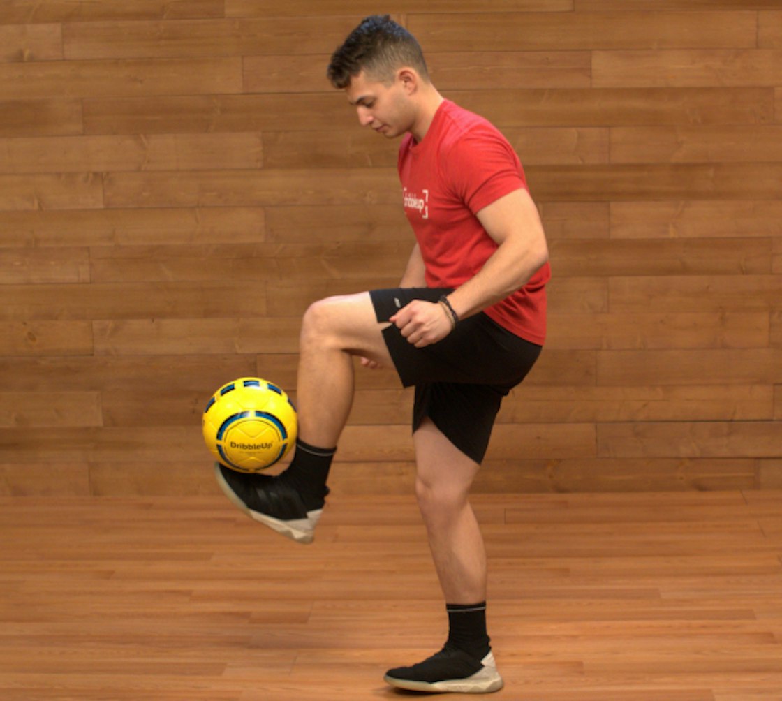 Soccer coach juggling a soccer ball