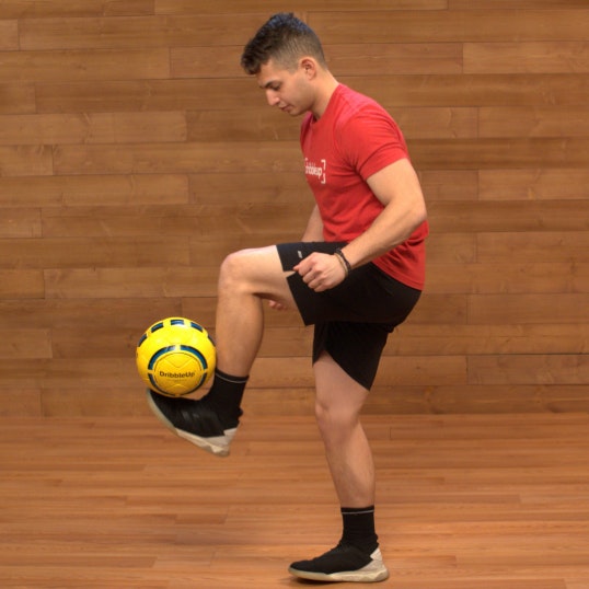 Soccer coach juggling a soccer ball