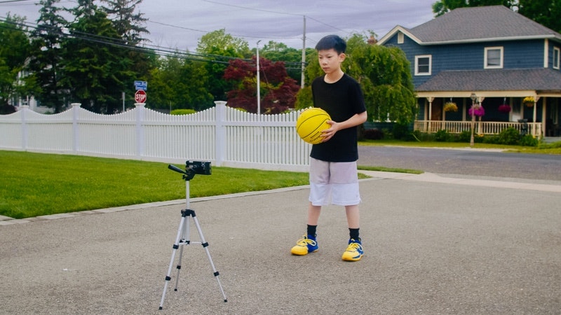 Young boy practicing the Up & Back Dribble in his driveway with the Dribbleup Smart Basketball.