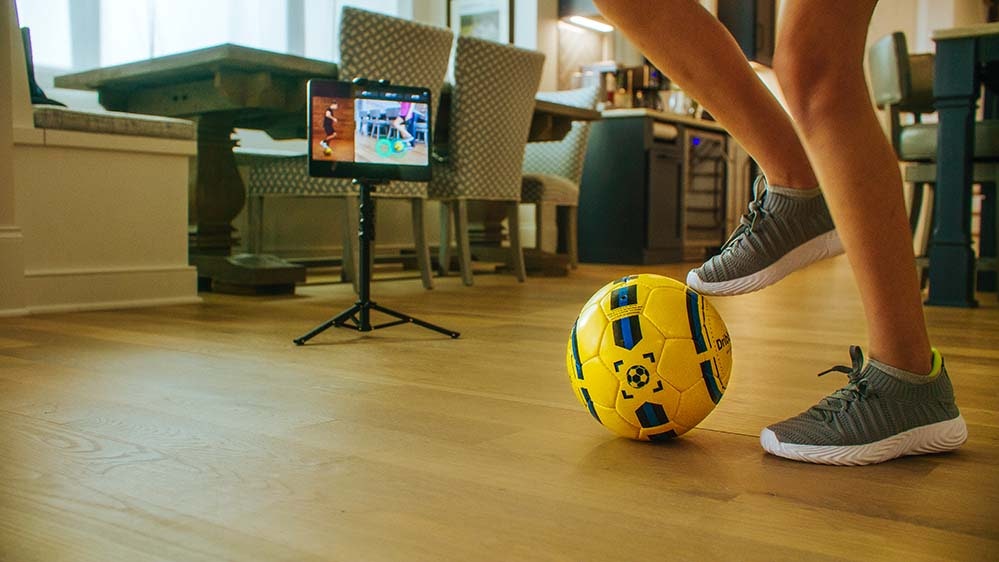 smart soccer ball at kid's feet and tablet