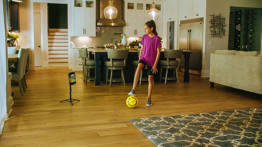 Child with smart soccer ball in house