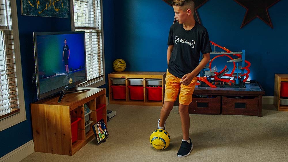 Young boy practicing in his living room with the Smart Soccer Ball.