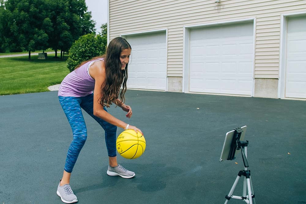 youth basketball player with dribbleup basketball and tablet