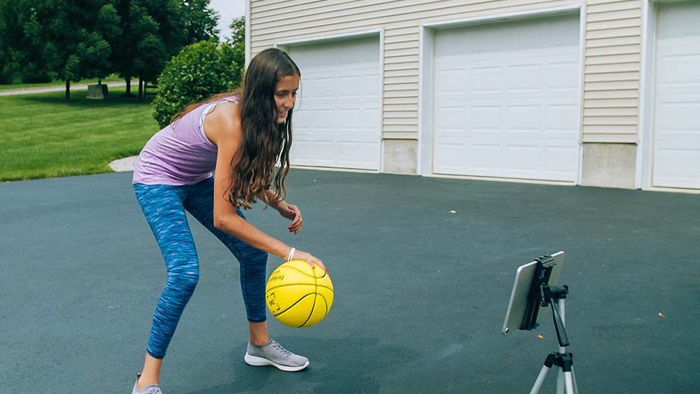 youth basketball player with dribbleup basketball and tablet