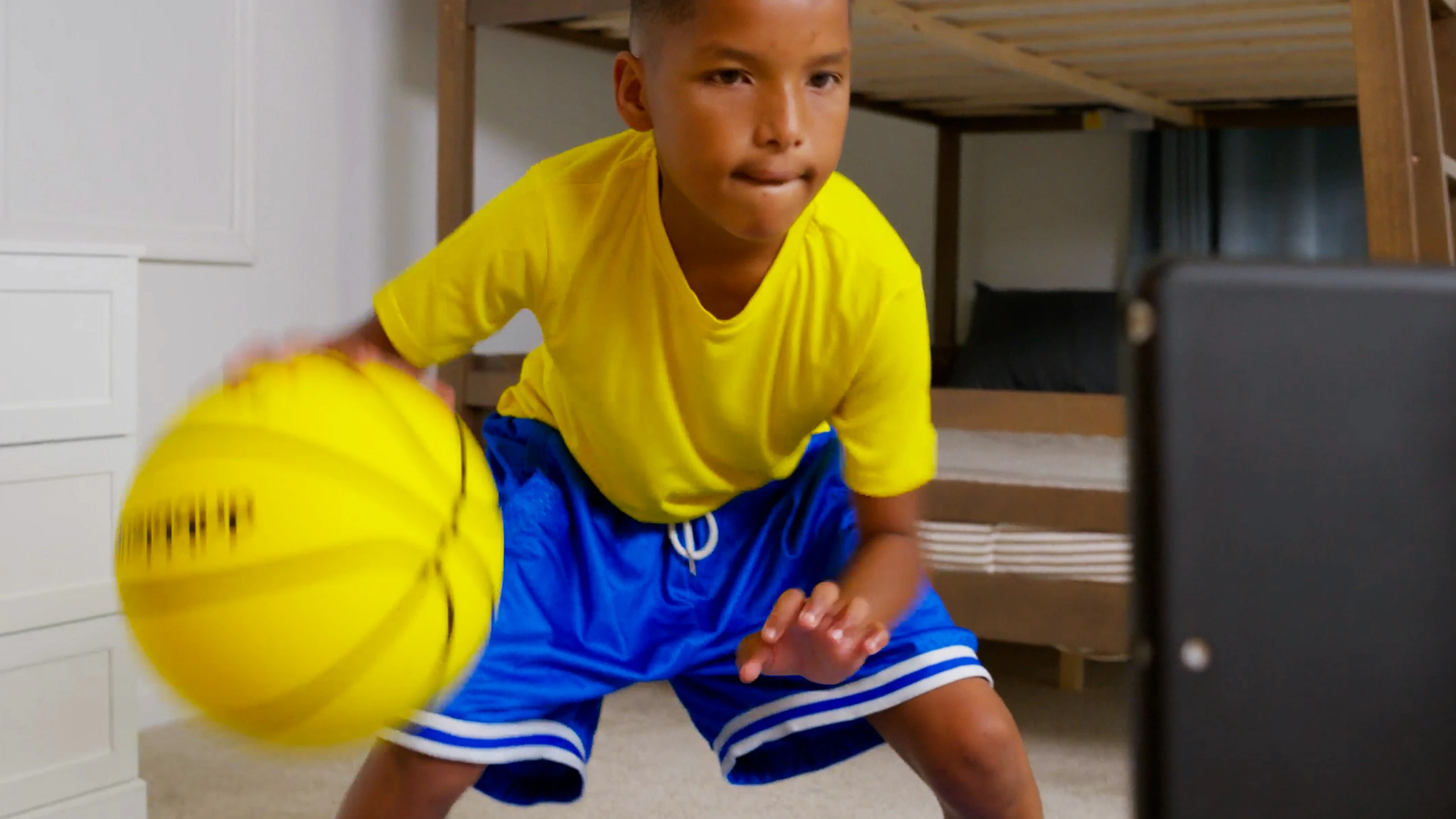 Boy running a dribbling drill with the Silent Smart Basketball in a carpeted bedroom